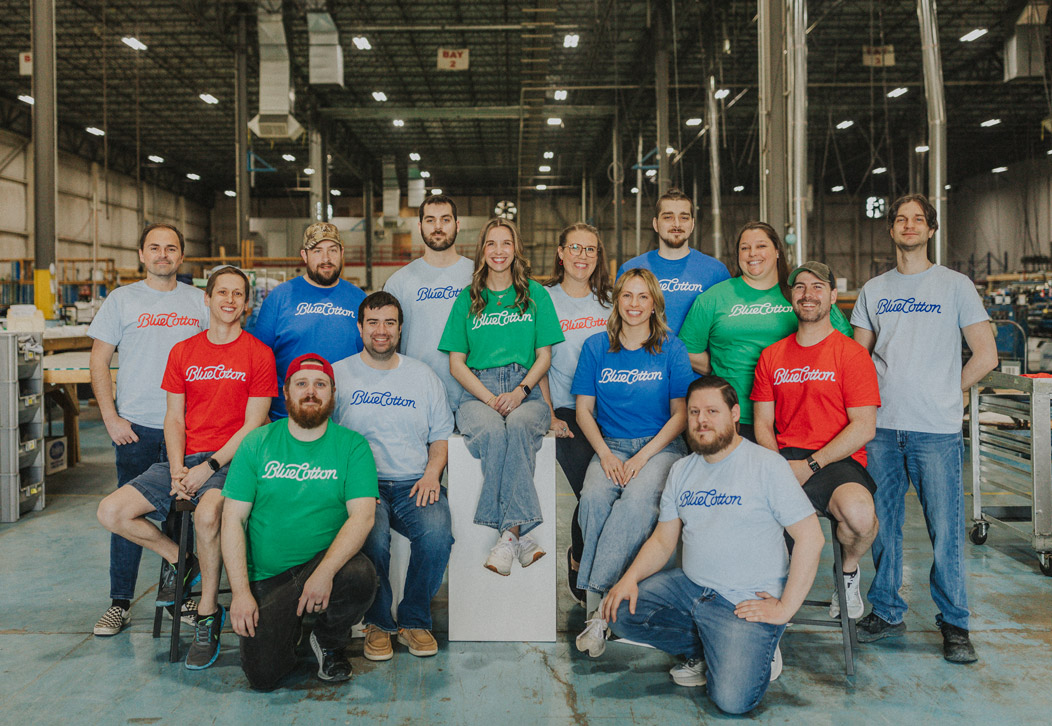 Group shot depicitng serval Bluecotton employees wearing custom apparel